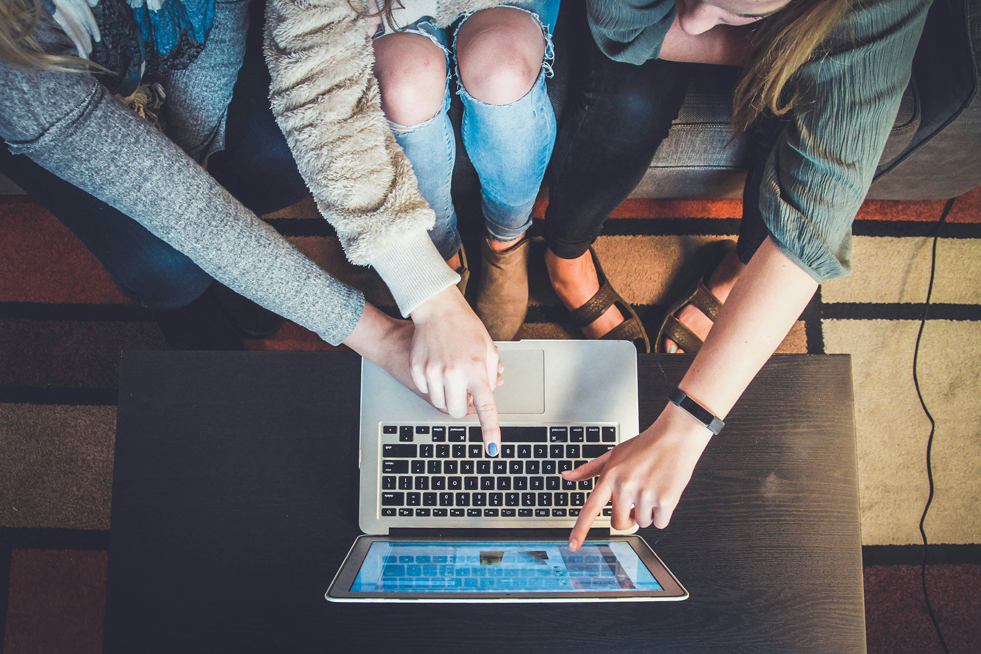 Three students using a laptop.
