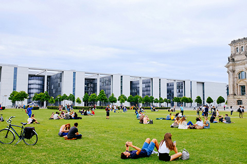 A group of students sitting outside on a sunny day.