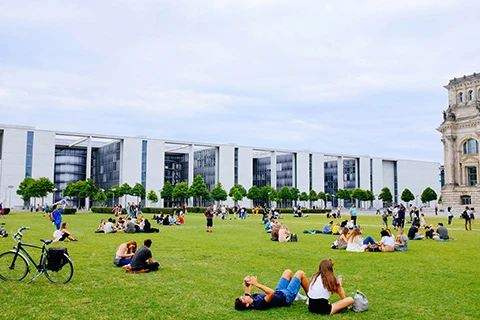 A group of students sitting outside on a sunny day.