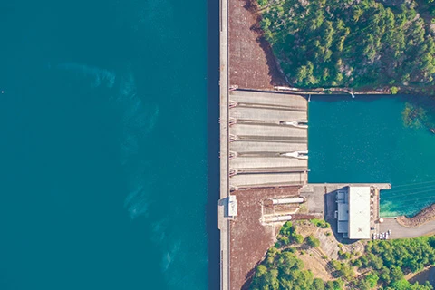 An overhead view of a reservoir and an enormous dam.
