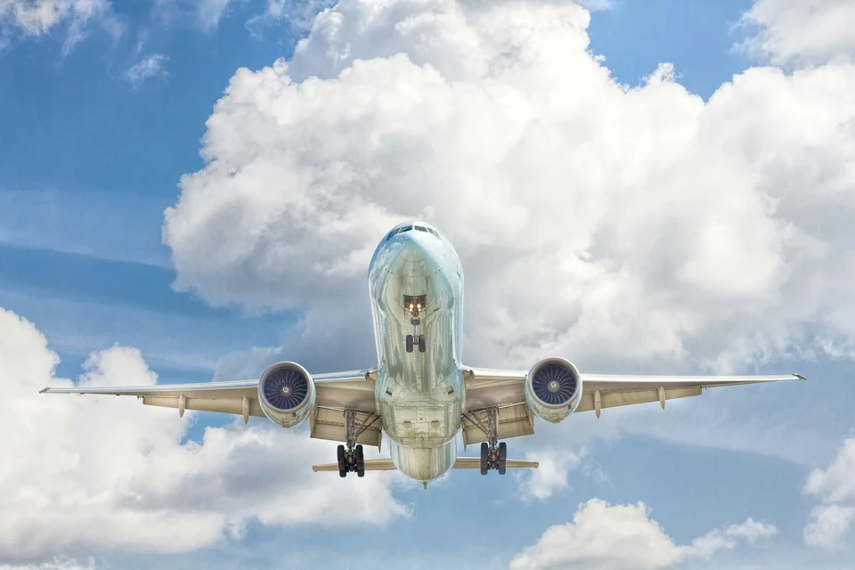 A plane landing on a sunny day.