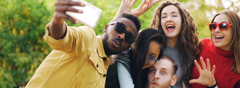 A group of students smiling and pulling faces for a selfie.