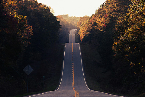 A long road disappears off in the distance.