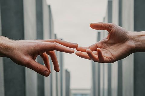 Outstretched hands reaching for each other.