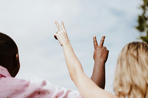 Two people making the peace sign.